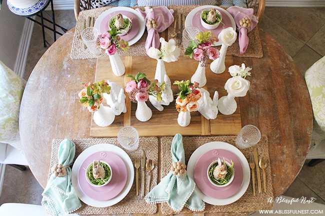 A beautiful and soft Easter table decor setting that is the perfect transition into spring. Soft whites with pops of flowers and pastels makes this Easter table setting perfect for your family! Check out more of this table on ablisfulnest.com