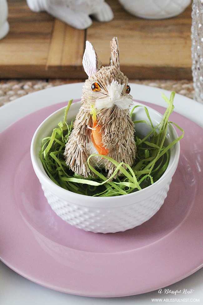 A beautiful and soft Easter table decor setting that is the perfect transition into spring. Soft whites with pops of flowers and pastels makes this Easter table setting perfect for your family! Check out more of this table on ablisfulnest.com