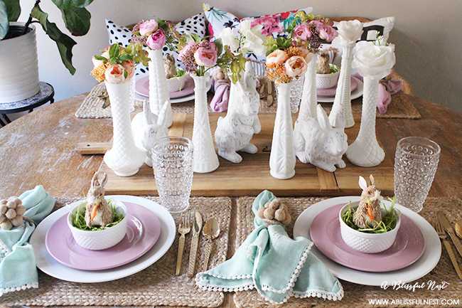 A beautiful and soft Easter table decor setting that is the perfect transition into spring. Soft whites with pops of flowers and pastels makes this Easter table setting perfect for your family! Check out more of this table on ablisfulnest.com