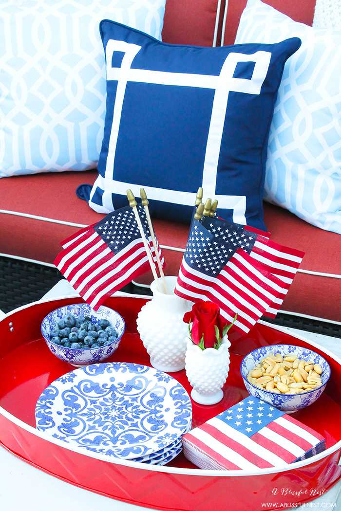 These are such great ideas to celebrate 4th of July with! I love all the Americana red, white and blue pops of color on this patio. Check out more on A Blissful Nest. https://ablisfulnest.com #4thofjuly #4thofjulydecor #redwhiteandblue