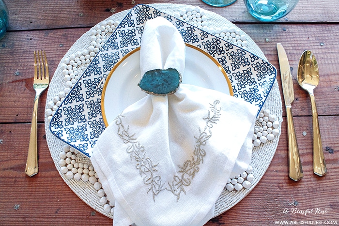 Fresh coastal table décor ideas for the perfect summer night. Grab these tips on setting the perfect coastal tablescape by A Blissful Nest. https://ablisfulnest.com/ #coastal #tabledecor #tabledecorideas #coastalinteriors #coastalroom #ocean #blueandwhite