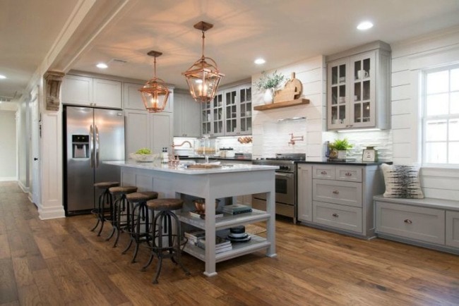 The copper and mixed metal accents in this kitchen give it a rustic, industrial vibe, but the cute farmhouse window seating and gorgeous gray cabinet colors bring it all together! Mangolia Market The Carriage House, 20 Best Fixer Upper Rooms 