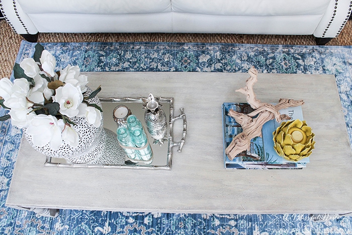If you love the coastal driftwood look then this is for you! Learn the easiest way to get a weathered wood finish featured on this coffee table makeover by A Blissful Nest. https://ablisfulnest.com/ #coastal #homedecor #diytutorial #tablemakeover #livingroom #driftwood #fauxfinish #weatheredwood
