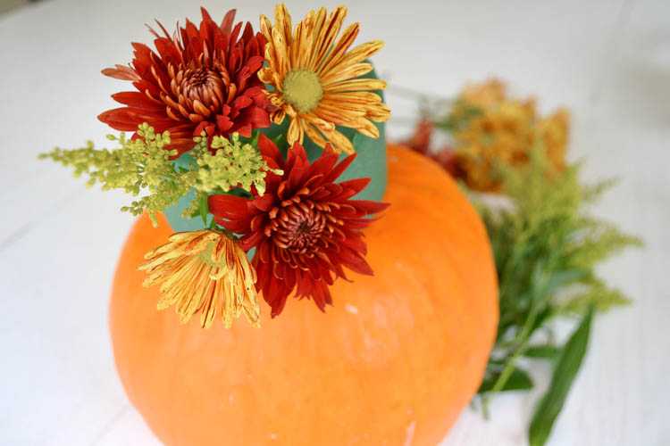 A super cute and simple DIY pumpkin centerpiece idea perfect for a fall table or Thanksgiving table idea! See more on https://ablisfulnest.com/ #falltable #pumpkinideas #falldecor