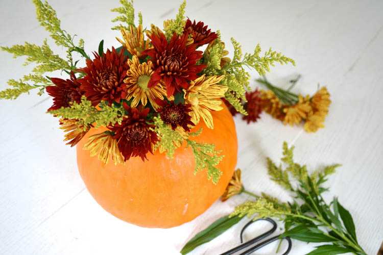 A super cute and simple DIY pumpkin centerpiece idea perfect for a fall table or Thanksgiving table idea! See more on https://ablisfulnest.com/ #falltable #pumpkinideas #falldecor