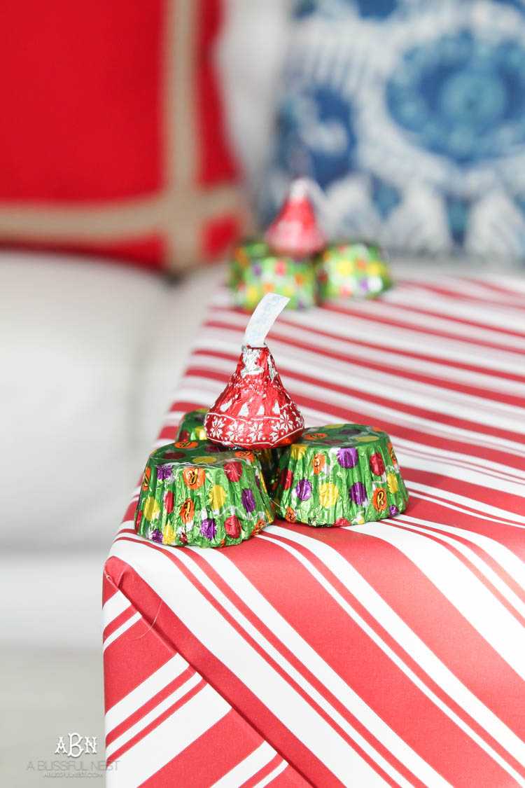Wrap your presents in chocolaty goodness with Hershey’s Kisses! This is such a fun and unique idea to decorate a gift. Then they can eat the candy later after the present has been opened! So fun! See more on https://ablisfulnest.com/ #hersheyskiss #christmascraft #christmasdiyidea