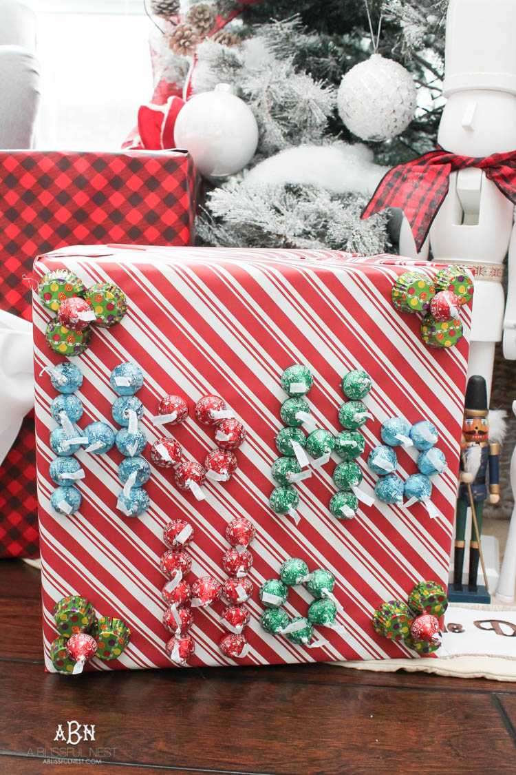 Wrap your presents in chocolaty goodness with Hershey’s Kisses! This is such a fun and unique idea to decorate a gift. Then they can eat the candy later after the present has been opened! So fun! See more on https://ablisfulnest.com/ #hersheyskiss #christmascraft #christmasdiyidea