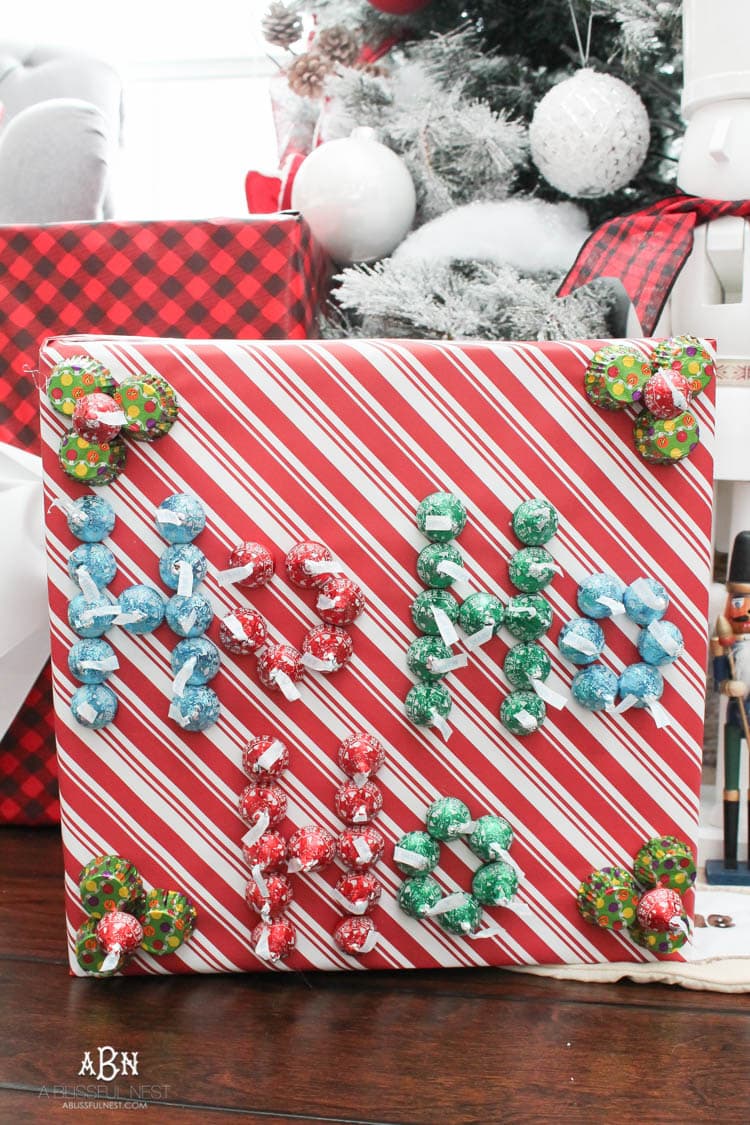 Wrap your presents in chocolaty goodness with Hershey’s Kisses! This is such a fun and unique idea to decorate a gift. Then they can eat the candy later after the present has been opened! So fun! See more on https://ablisfulnest.com/ #hersheyskiss #christmascraft #christmasdiyidea