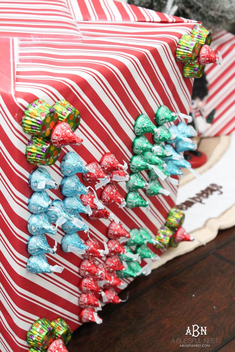Wrap your presents in chocolaty goodness with Hershey’s Kisses! This is such a fun and unique idea to decorate a gift. Then they can eat the candy later after the present has been opened! So fun! See more on https://ablisfulnest.com/ #hersheyskiss #christmascraft #christmasdiyidea