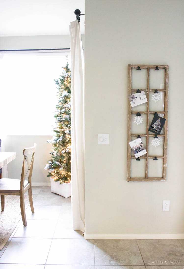 Use an old window and some clips to create a one-of-a-king Christmas card display. It makes for a beautiful decor piece in your home! See it all on https://ablisfulnest.com/ #Christmas #CHristmasCards #VintageDecor