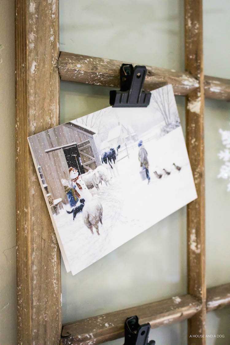 Use an old window and some clips to create a one-of-a-king Christmas card display. It makes for a beautiful decor piece in your home! See it all on https://ablisfulnest.com/ #Christmas #CHristmasCards #VintageDecor