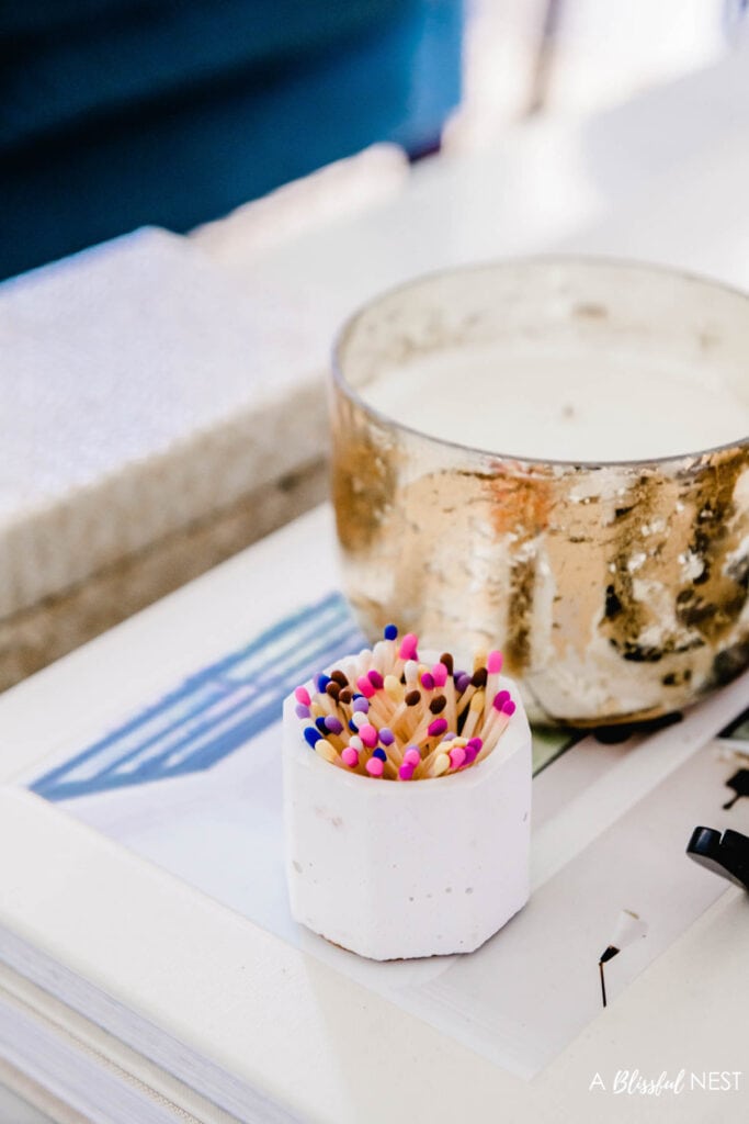 white vessel holding different colored matches on a table.