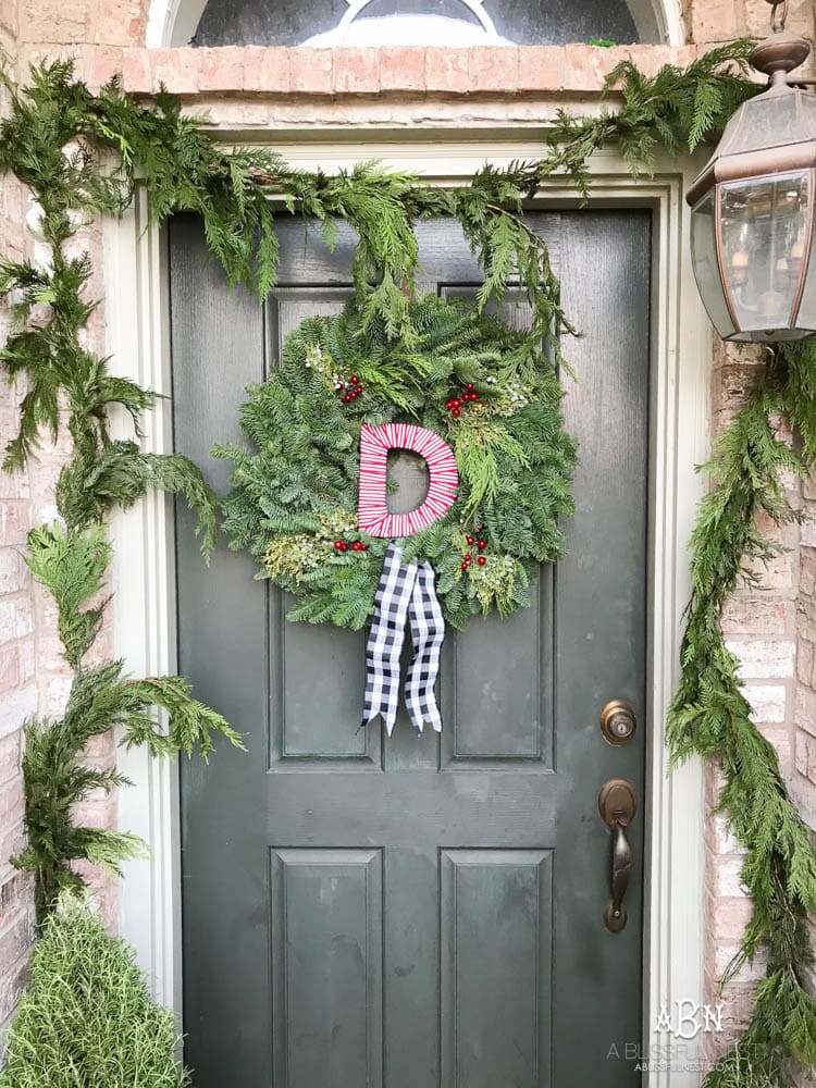 A classic christmas porch and beautiful neutral Christmas dining room idea. See more on https://ablisfulnest.com/ #christmasdecor #christmasideas #christmasfront porch #christmasdecoratingideas