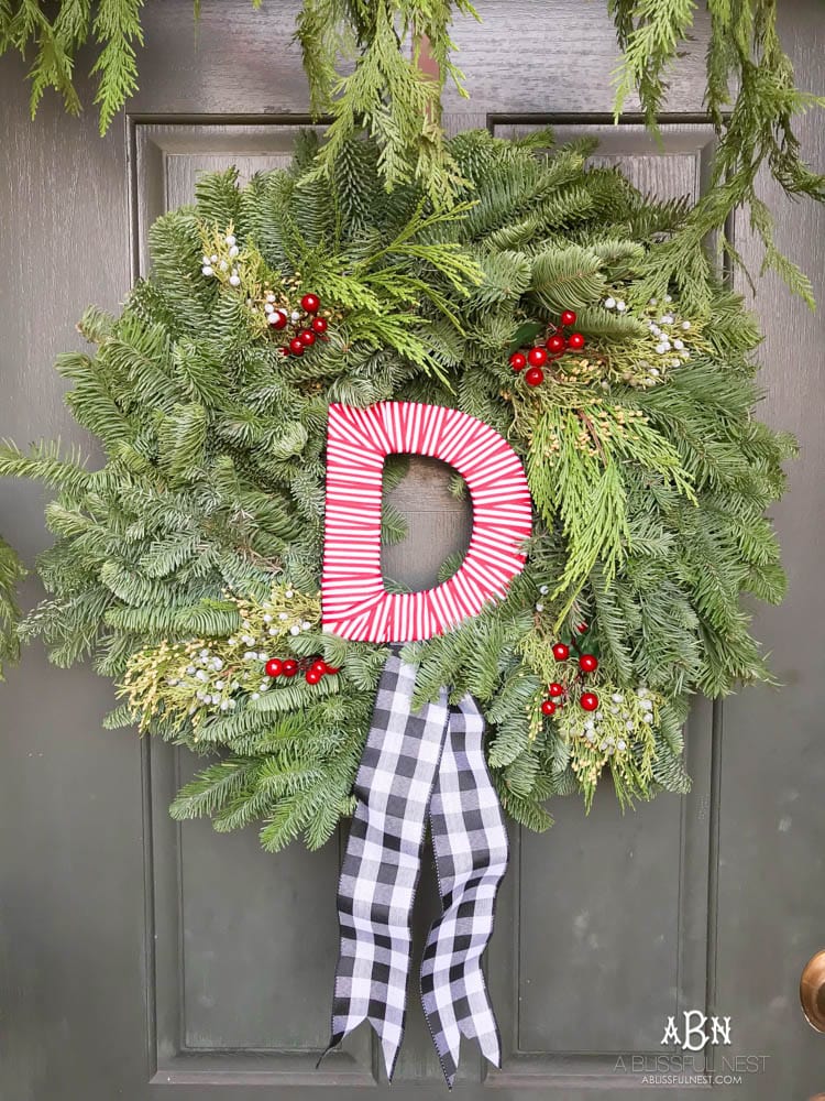 A classic christmas porch and beautiful neutral Christmas dining room idea. See more on https://ablisfulnest.com/ #christmasdecor #christmasideas #christmasfront porch #christmasdecoratingideas