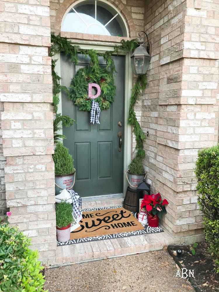 A classic christmas porch and beautiful neutral Christmas dining room idea. See more on https://ablisfulnest.com/ #christmasdecor #christmasideas #christmasfront porch #christmasdecoratingideas