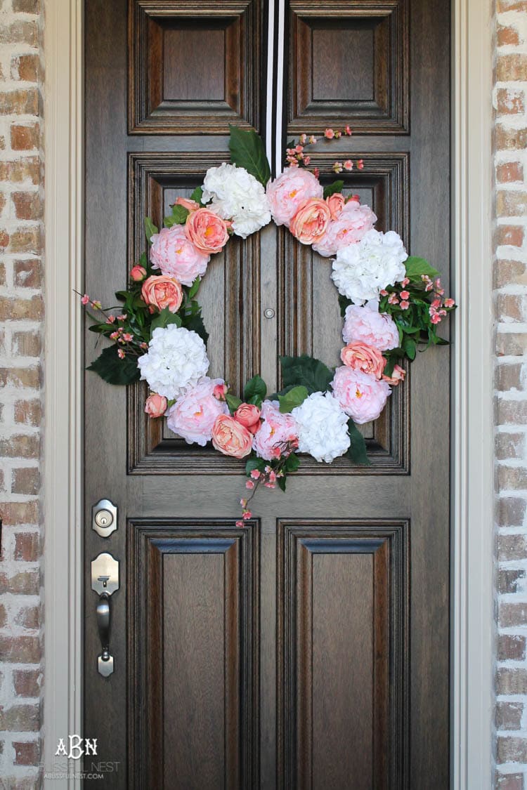Adding pop of pinks a a DIY wreath makes this spring porch pop! #springporch #springfrontporch #springdecorating #springdecoratingideas