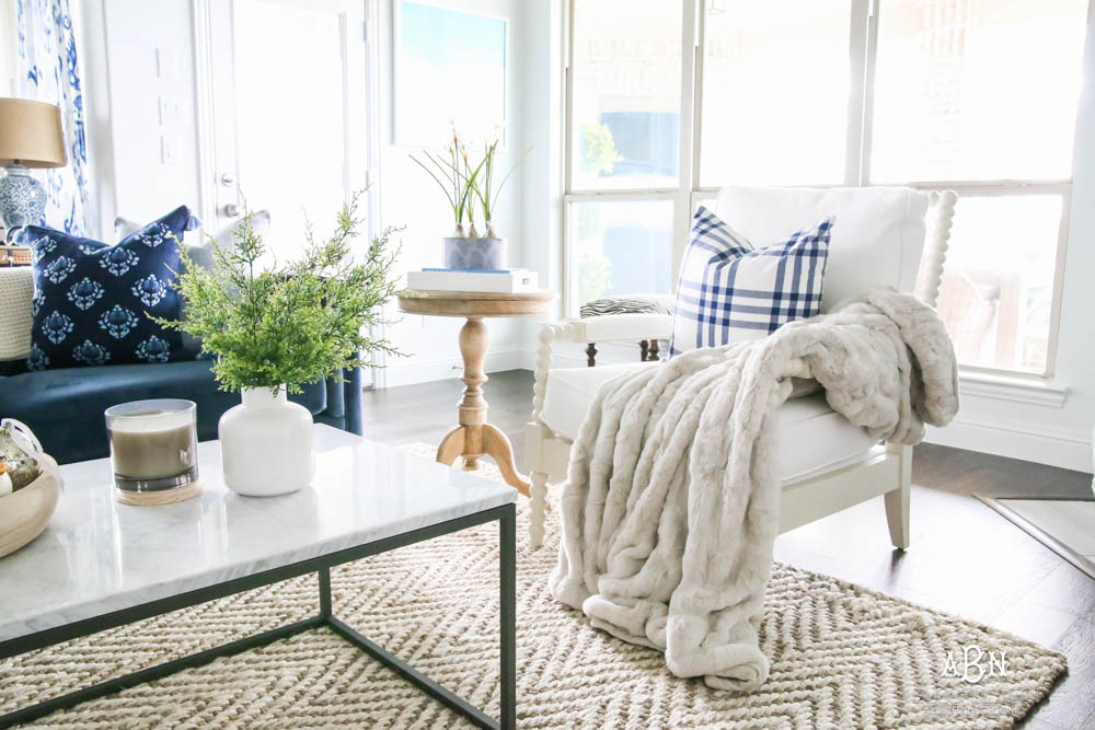 Beautiful blue and silver Christmas living room decor in a bright white space with juniper garland and silver and blush ornaments. Check out all the white, silver and gold Christmas decor in this holiday home tour on ablisfulnest.com. #ABlissfulNest #Christmasdecor #Christmasdecorating #CoastalChristmasdecor #christmastree #christmasmantle