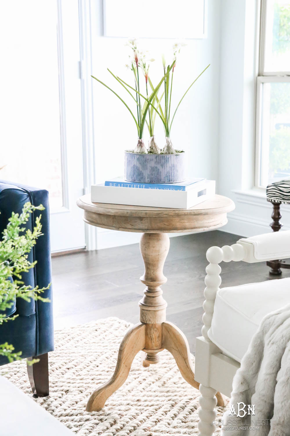 Beautiful blue and silver Christmas living room decor in a bright white space with juniper garland and silver and blush ornaments. Check out all the white, silver and gold Christmas decor in this holiday home tour on ablisfulnest.com. #ABlissfulNest #Christmasdecor #Christmasdecorating #CoastalChristmasdecor #christmastree #christmasmantle