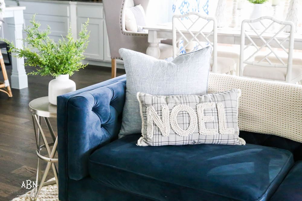 Beautiful blue and silver Christmas living room decor in a bright white space with juniper garland and silver and blush ornaments. Check out all the white, silver and gold Christmas decor in this holiday home tour on ablisfulnest.com. #ABlissfulNest #Christmasdecor #Christmasdecorating #CoastalChristmasdecor #christmastree #christmasmantle