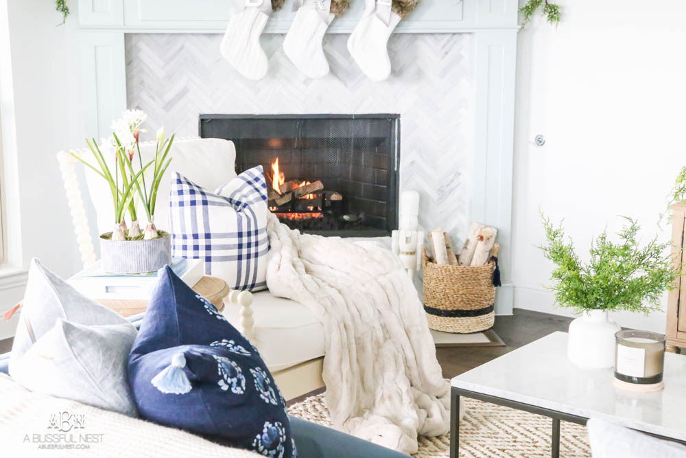 Beautiful blue and silver Christmas living room decor in a bright white space with juniper garland and silver and blush ornaments. Check out all the white, silver and gold Christmas decor in this holiday home tour on ablisfulnest.com. #ABlissfulNest #Christmasdecor #Christmasdecorating #CoastalChristmasdecor