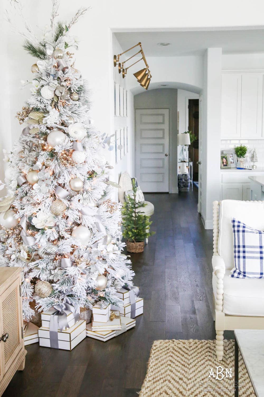 Silver and gold Christmas tree in an open concept floor plan with lots of blue home decor accents. Check out all the white, silver and gold Christmas decor in this holiday home tour on ablisfulnest.com. #ABlissfulNest #Christmasdecor #Christmasdecorating #CoastalChristmasdecor