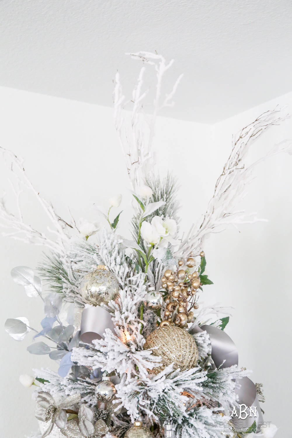 Silver and gold Christmas tree in an open concept floor plan with lots of blue home decor accents. Check out all the white, silver and gold Christmas decor in this holiday home tour on ablisfulnest.com. #ABlissfulNest #Christmasdecor #Christmasdecorating #CoastalChristmasdecor #christmastree