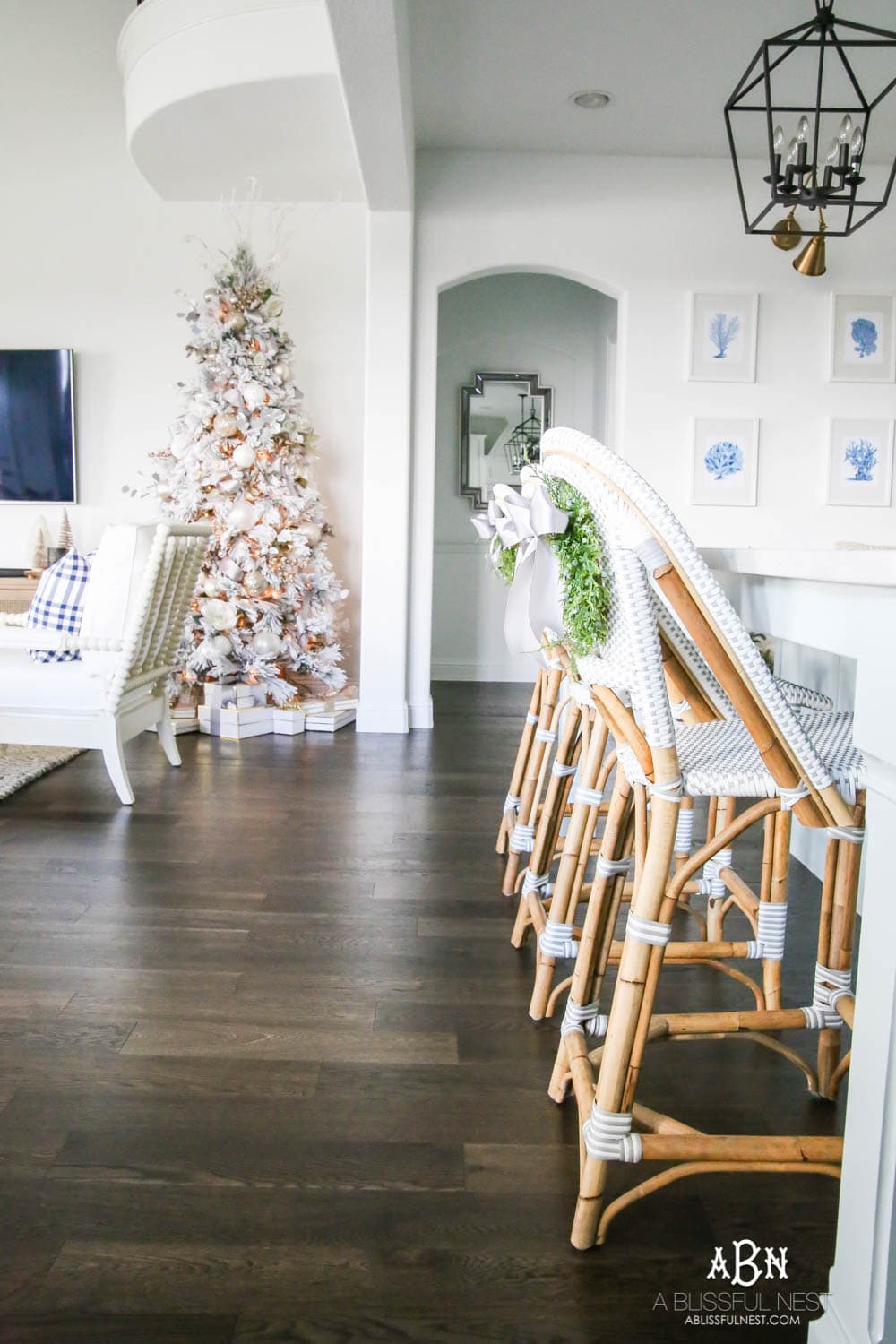 Beautiful blue and silver Christmas living room decor in a bright white space with juniper garland and silver and blush ornaments. Check out all the white, silver and gold Christmas decor in this holiday home tour on ablisfulnest.com. #ABlissfulNest #Christmasdecor #Christmasdecorating #CoastalChristmasdecor #christmastree #christmasmantle