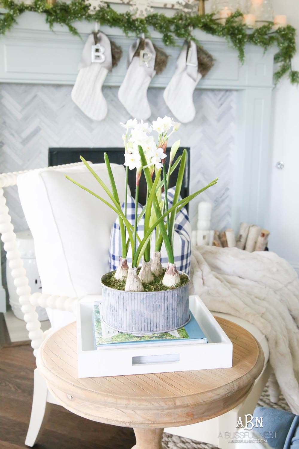 Beautiful blue and silver Christmas living room decor in a bright white space with juniper garland and silver and blush ornaments. Check out all the white, silver and gold Christmas decor in this holiday home tour on ablisfulnest.com. #ABlissfulNest #Christmasdecor #Christmasdecorating #CoastalChristmasdecor #christmastree #christmasmantle