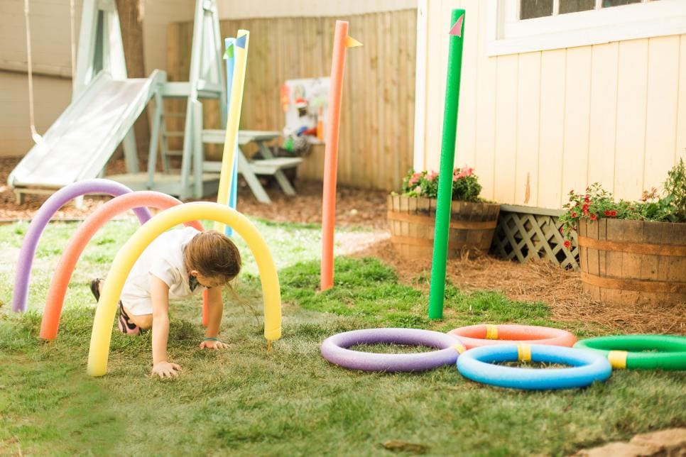 obstacle course made from pool noodles with a child crawling through