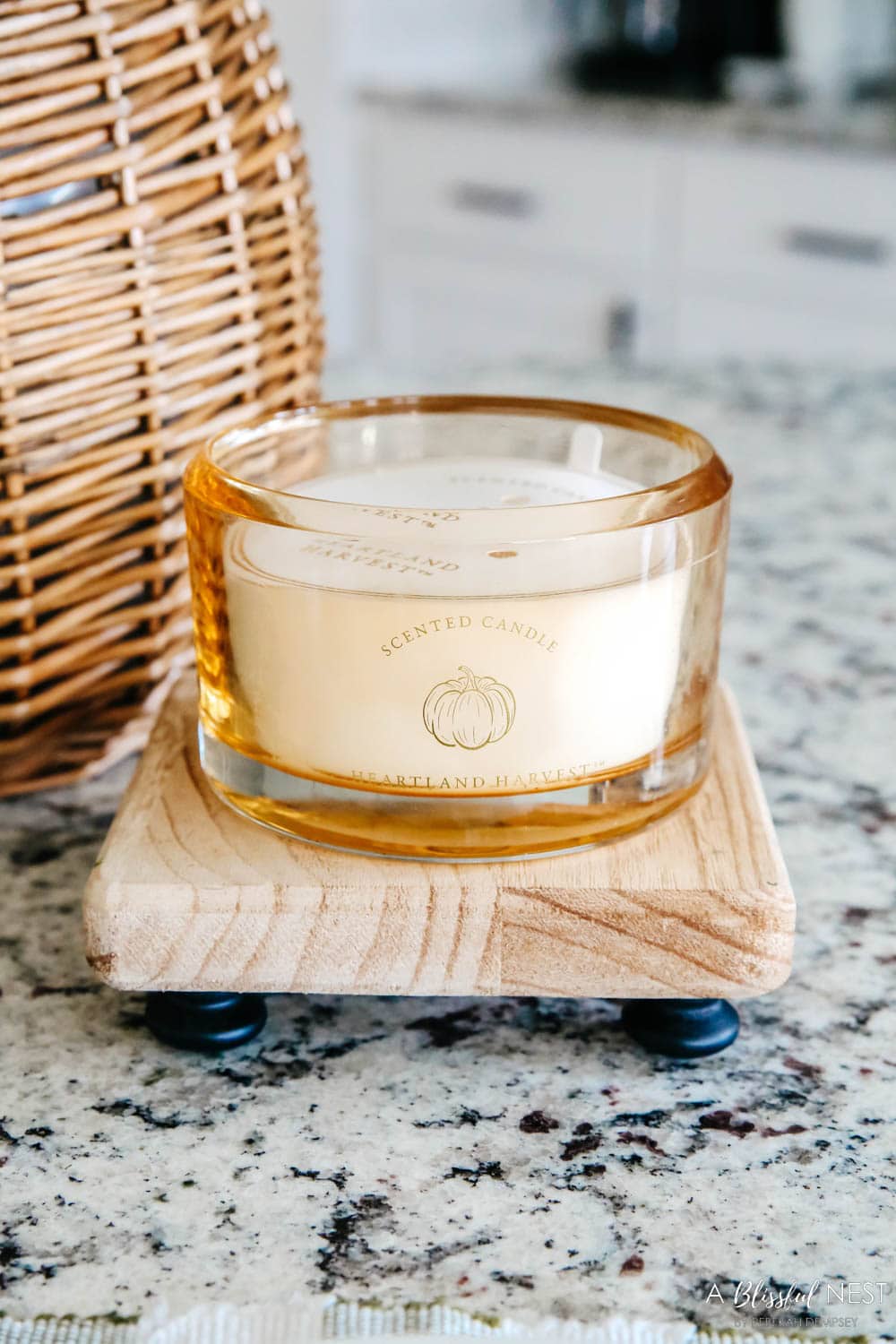 A fall scented candle on a wood tray. 
