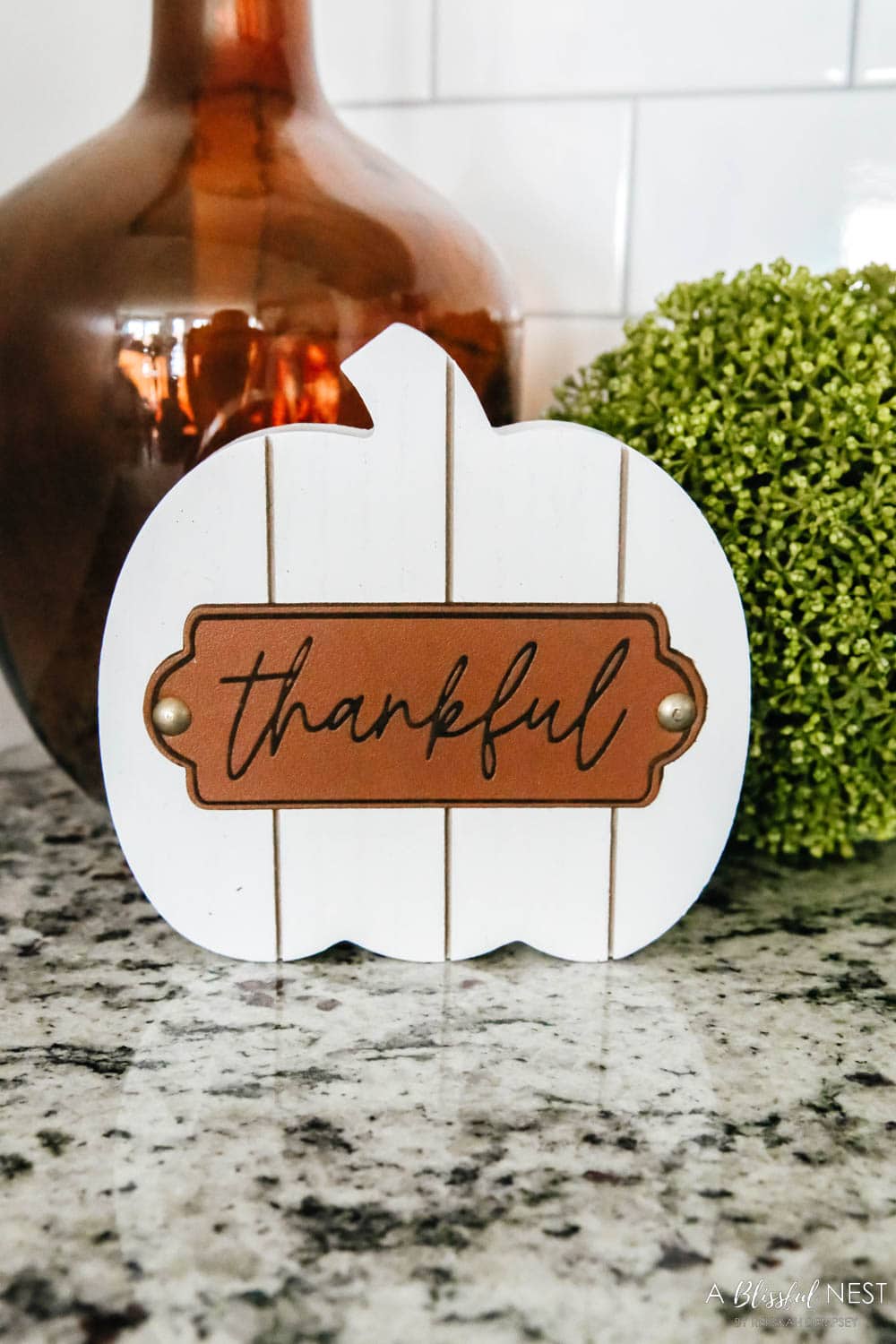 Small white wood plank pumpkin with a leather accent.