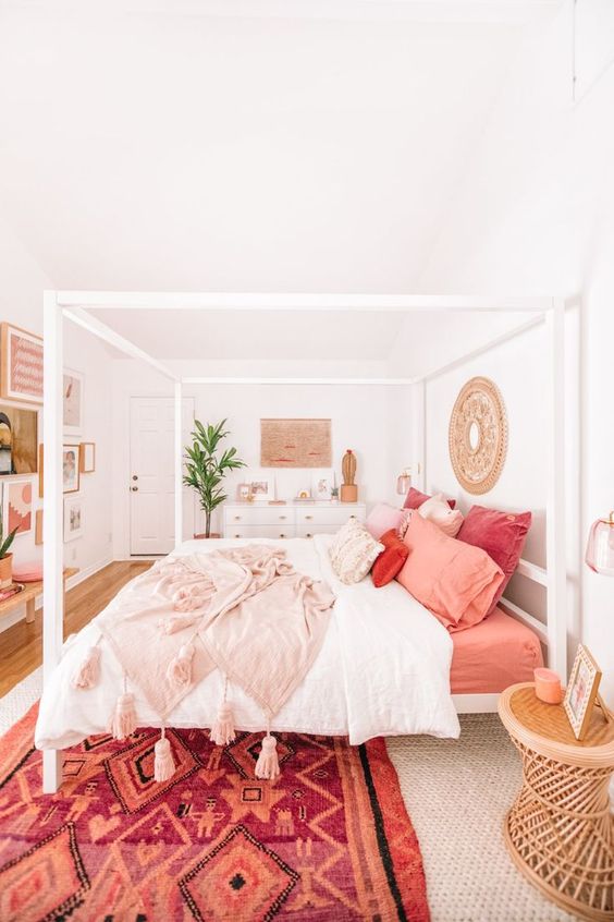 A bright and colorful bedroom with shades of mauve, blush and orange in the bedding. 