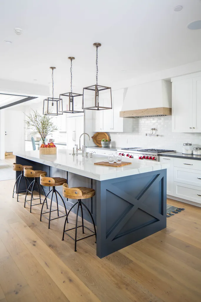 blue kitchen island, white kitchen cabinets, black pendant lanterns, industrial wood barstools