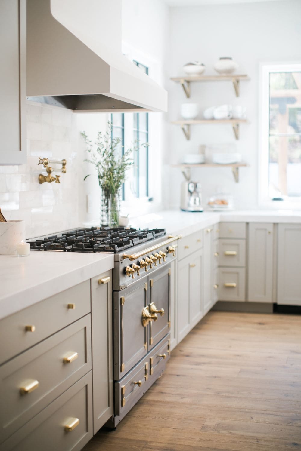 greige kitchen cabinets with gold hardware and vintage oven.