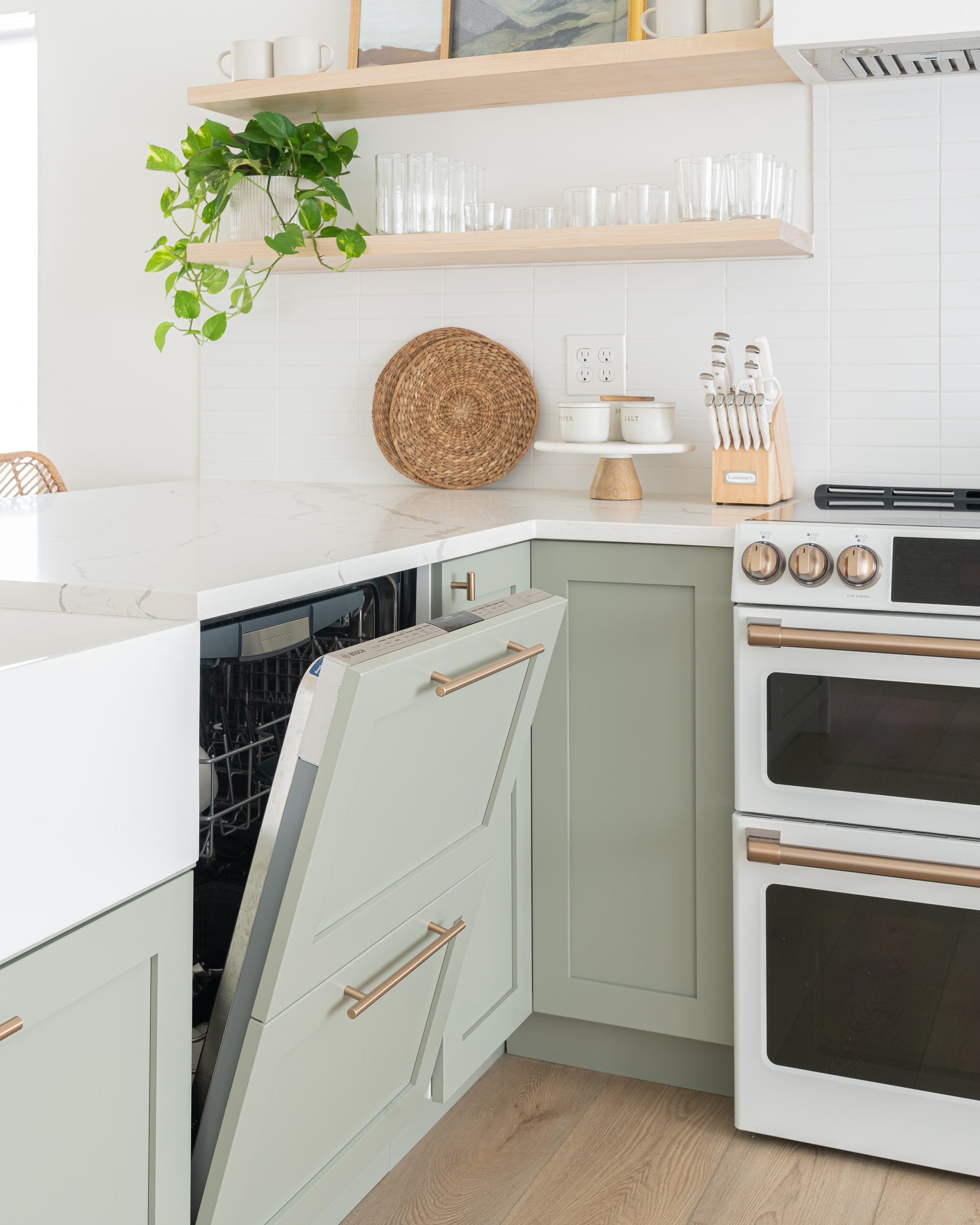 sage green cabinets, white quartz, wood floating shelves, gold cabinet hardware