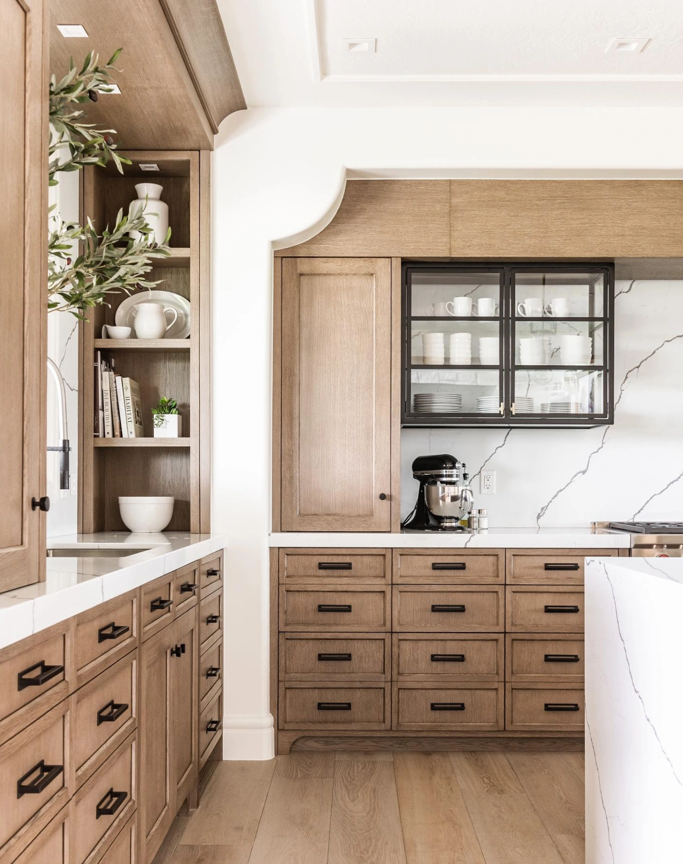 oak cabinets with black hardware in kitchen with thick quartz countertops