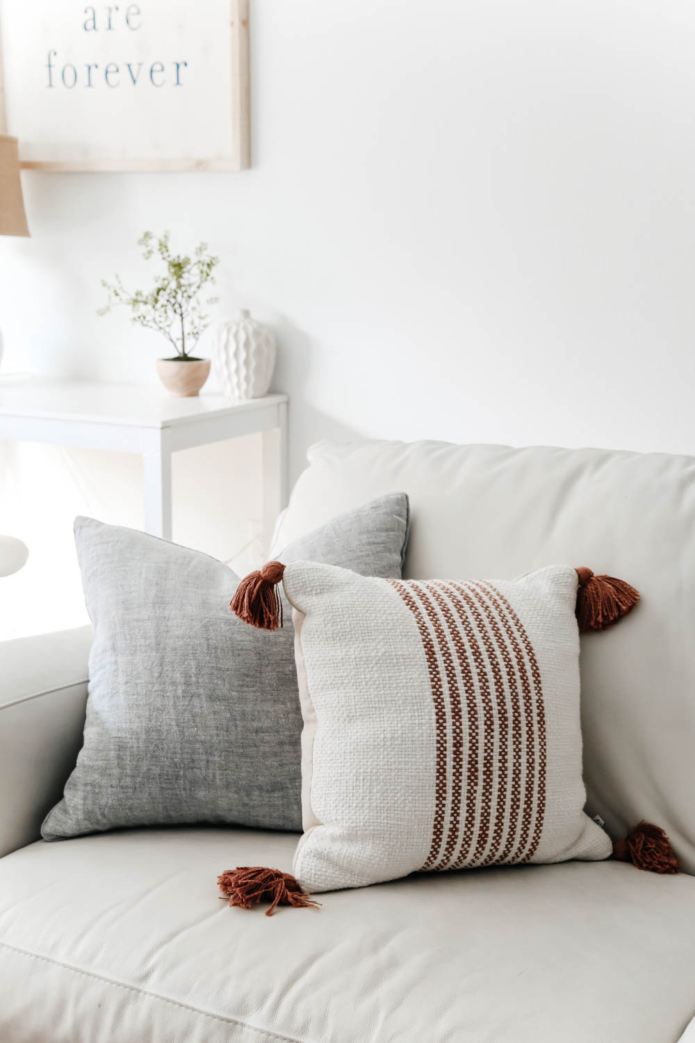Light blue solid pillow paired with rust colored stripe pillow with white accents.