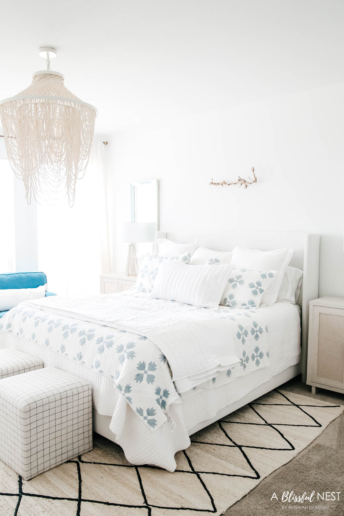 quilt layered on top of a coverlet on a all white bed
