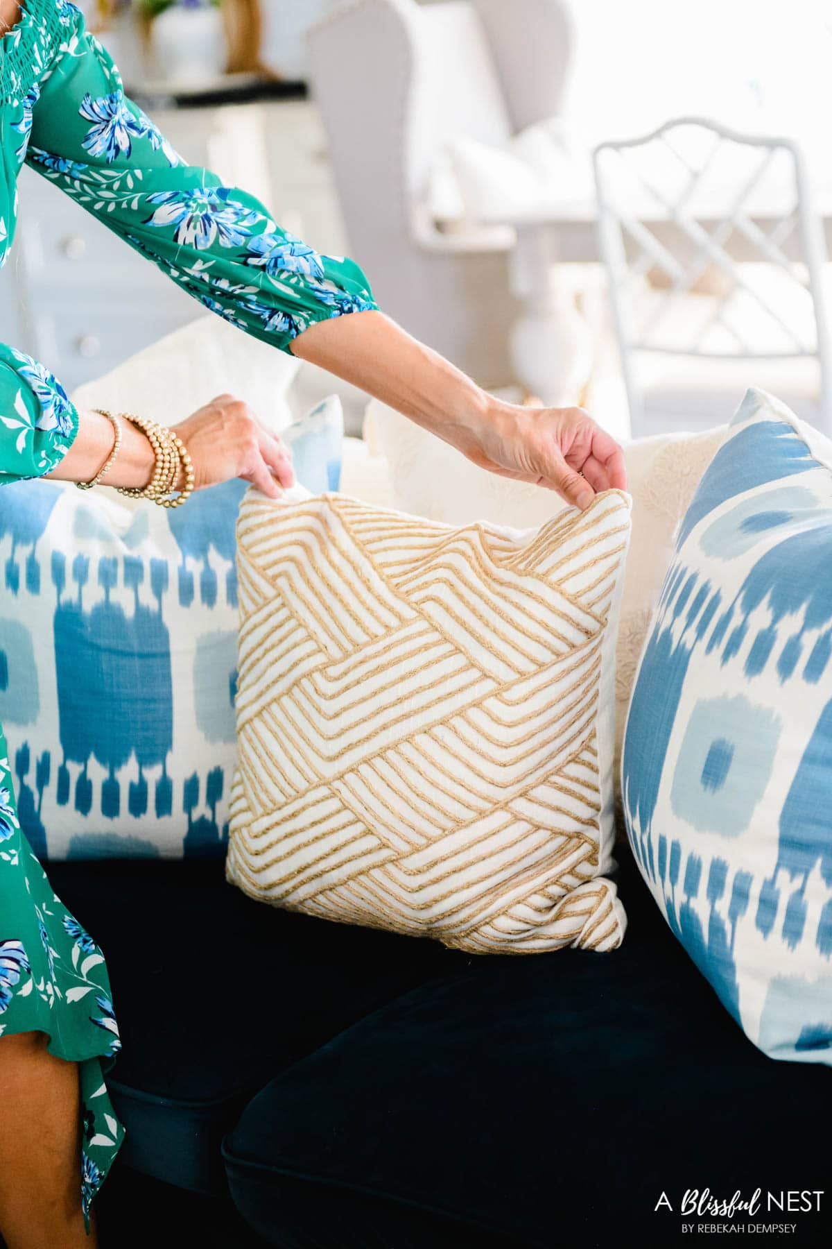 jute accents on a white pillow mixed with an ikat blue and white pillow on a nay sofa.