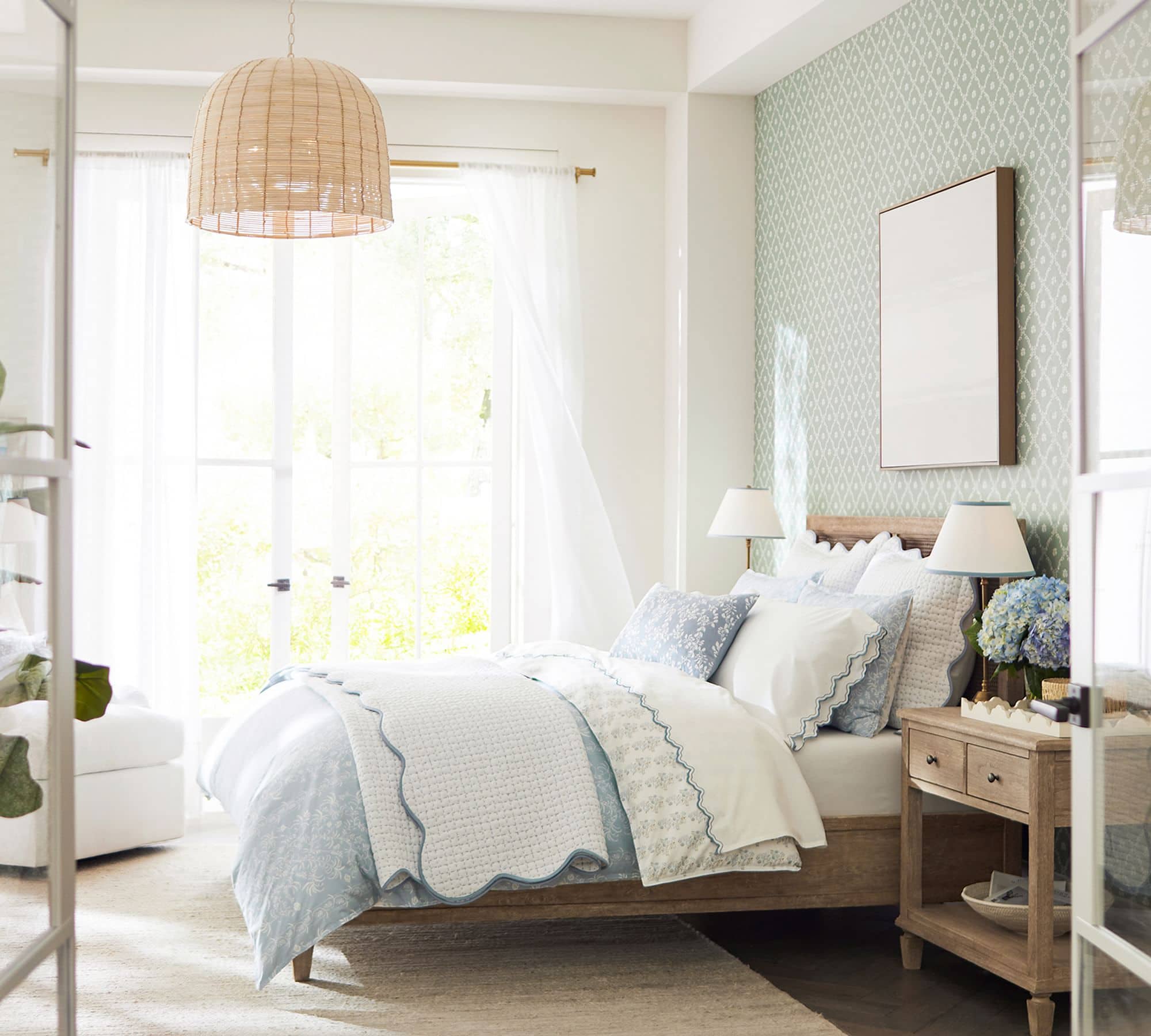 white coverlet with scalloped edge detail in blue paired with soft blue and white bedding