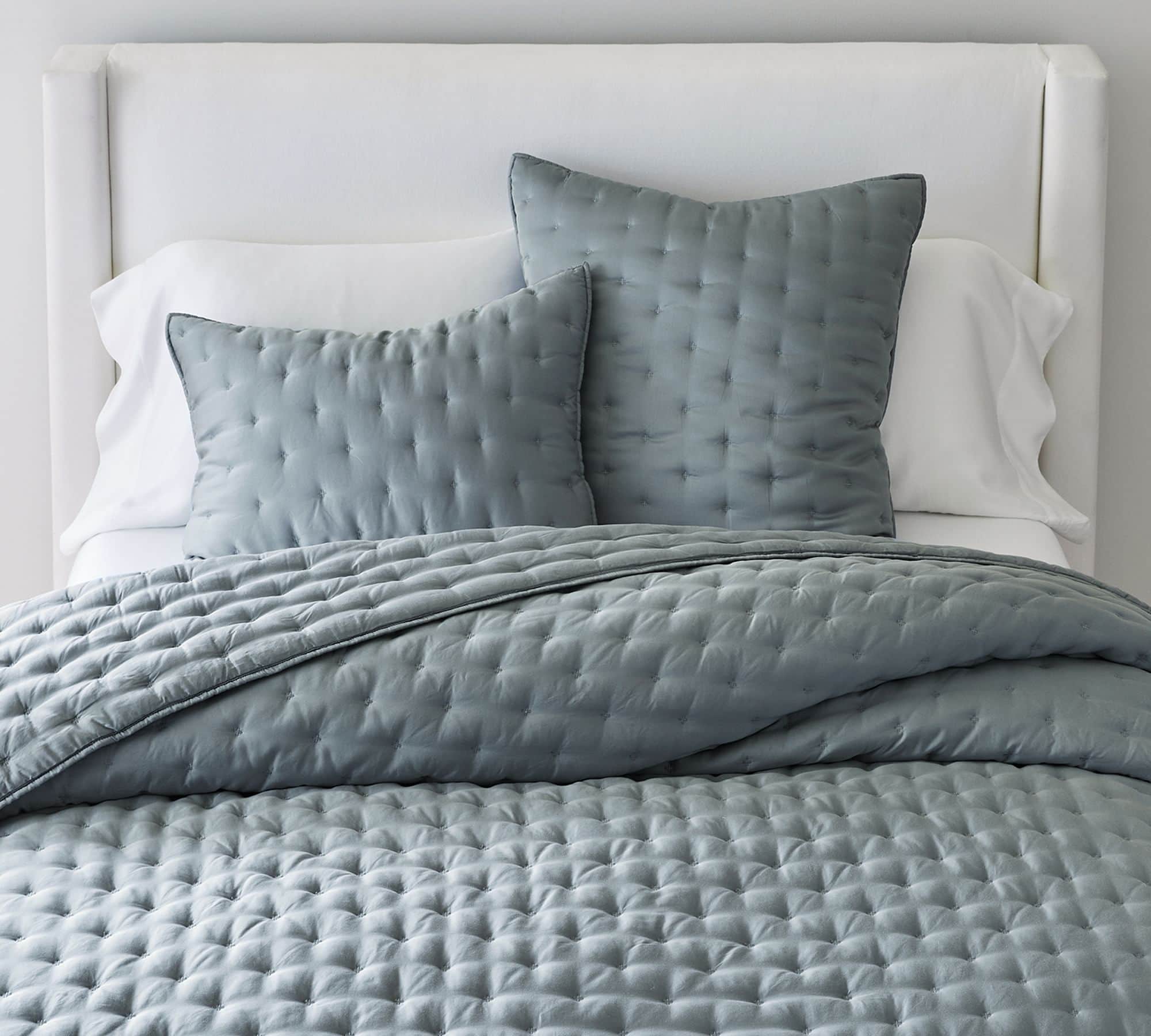 Dark blue green coverlet with matching shams mixed with white bedding