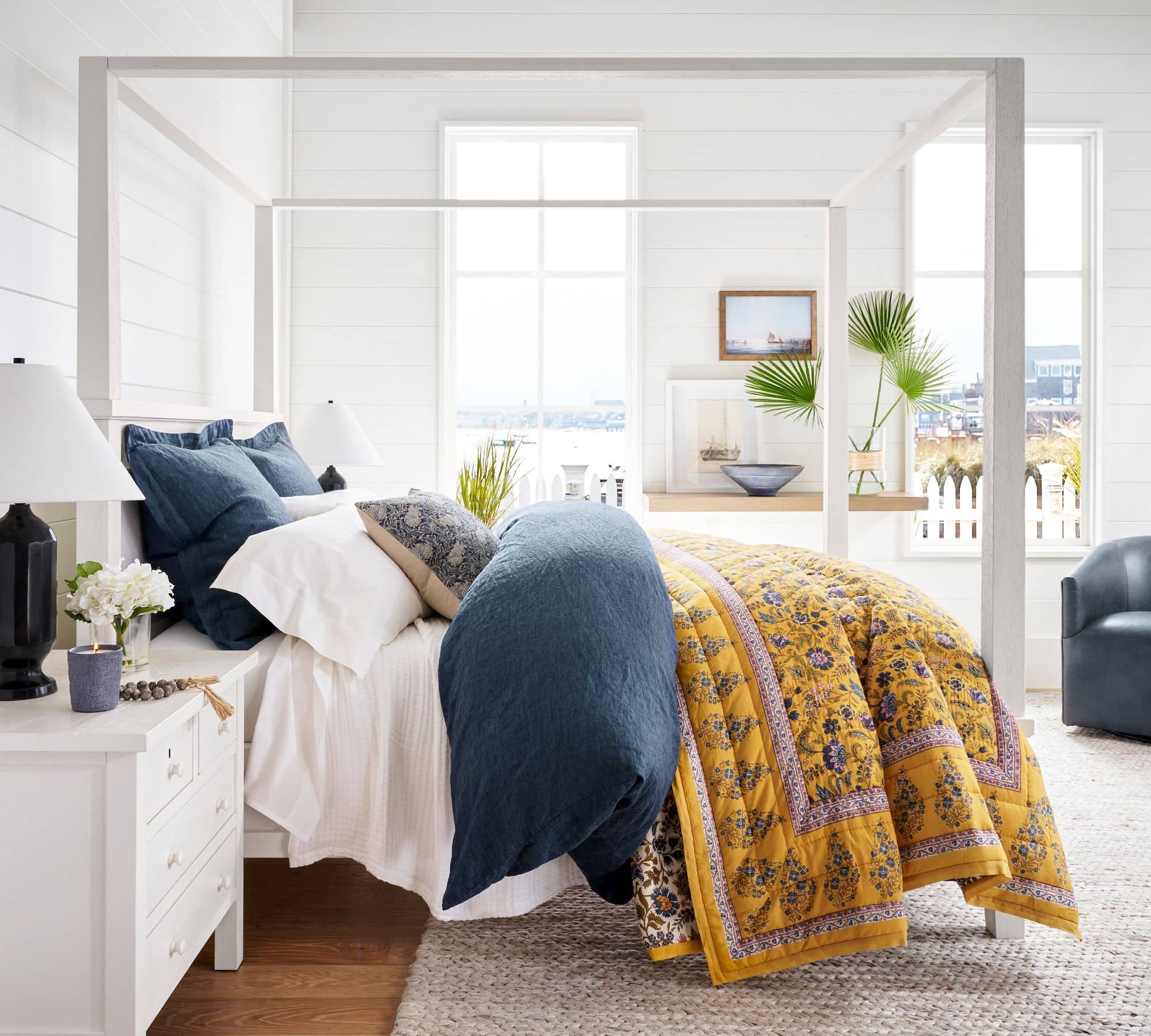 Navy blue duvet cover and shams mixed with blue and yellow patterned quilt.