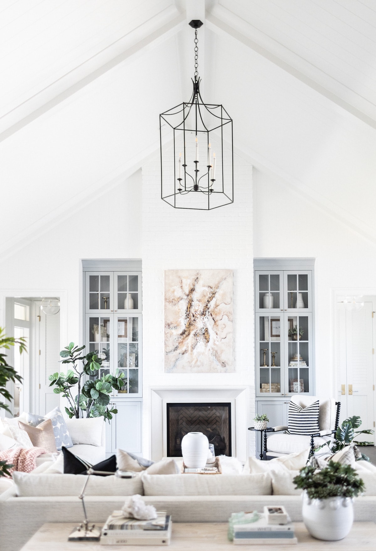 White walls with soft gray blue built in cabinets on either side of the fireplace.