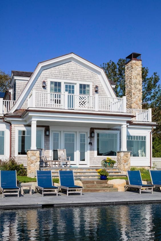 cape code style home showing back exterior with a pool