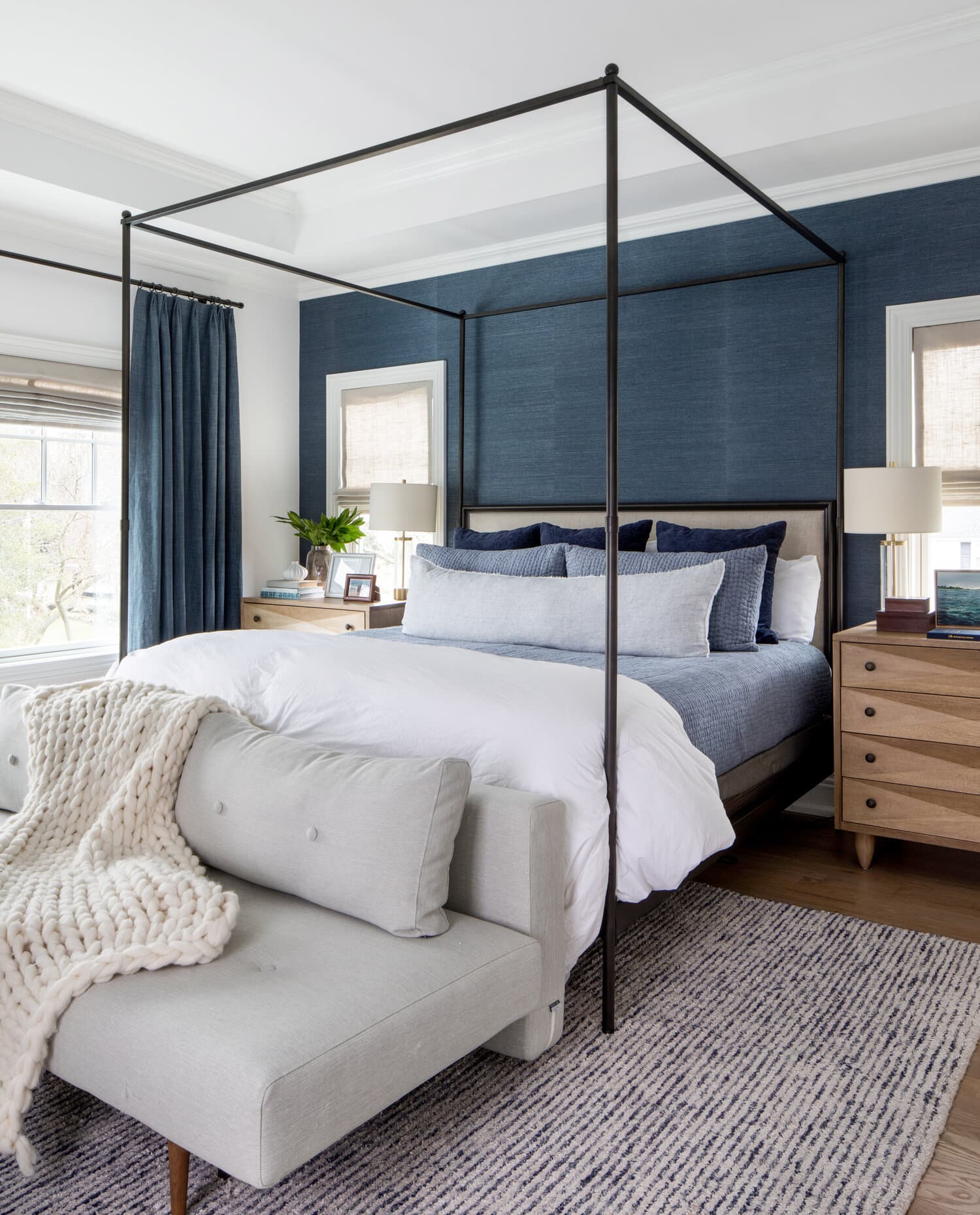 black canopy bed against a navy wall