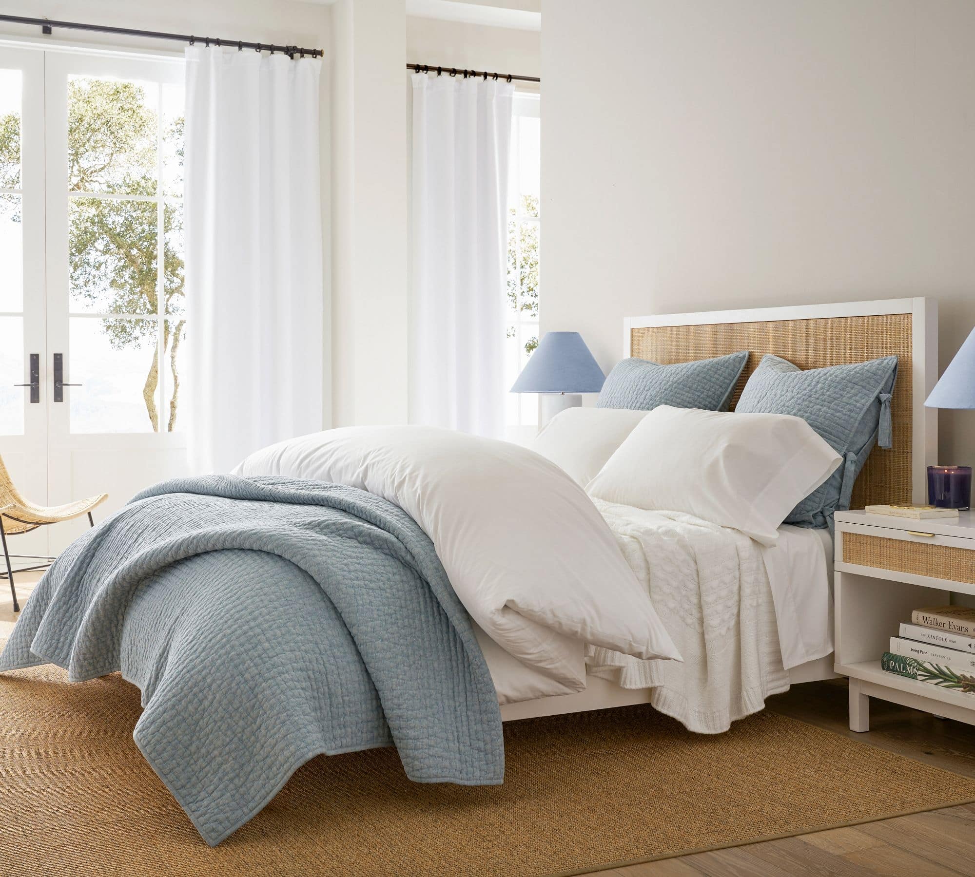 blue and white bedding with a cane headboard