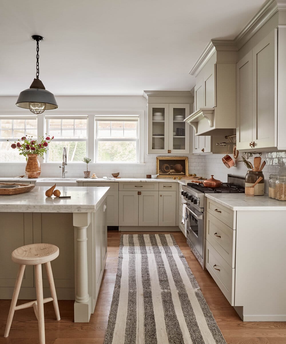 sage green kitchen cabinets, bronze cabinet hardware, honey oak wood flooring