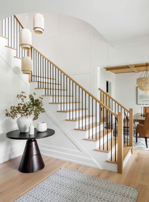 modern black round table next to a staircase in an entryway
