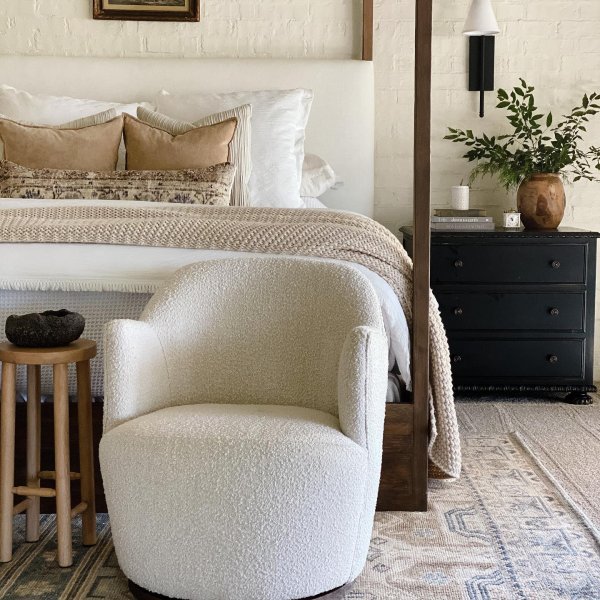 beige chunky knit throw blanket layered at the bottom of a bed