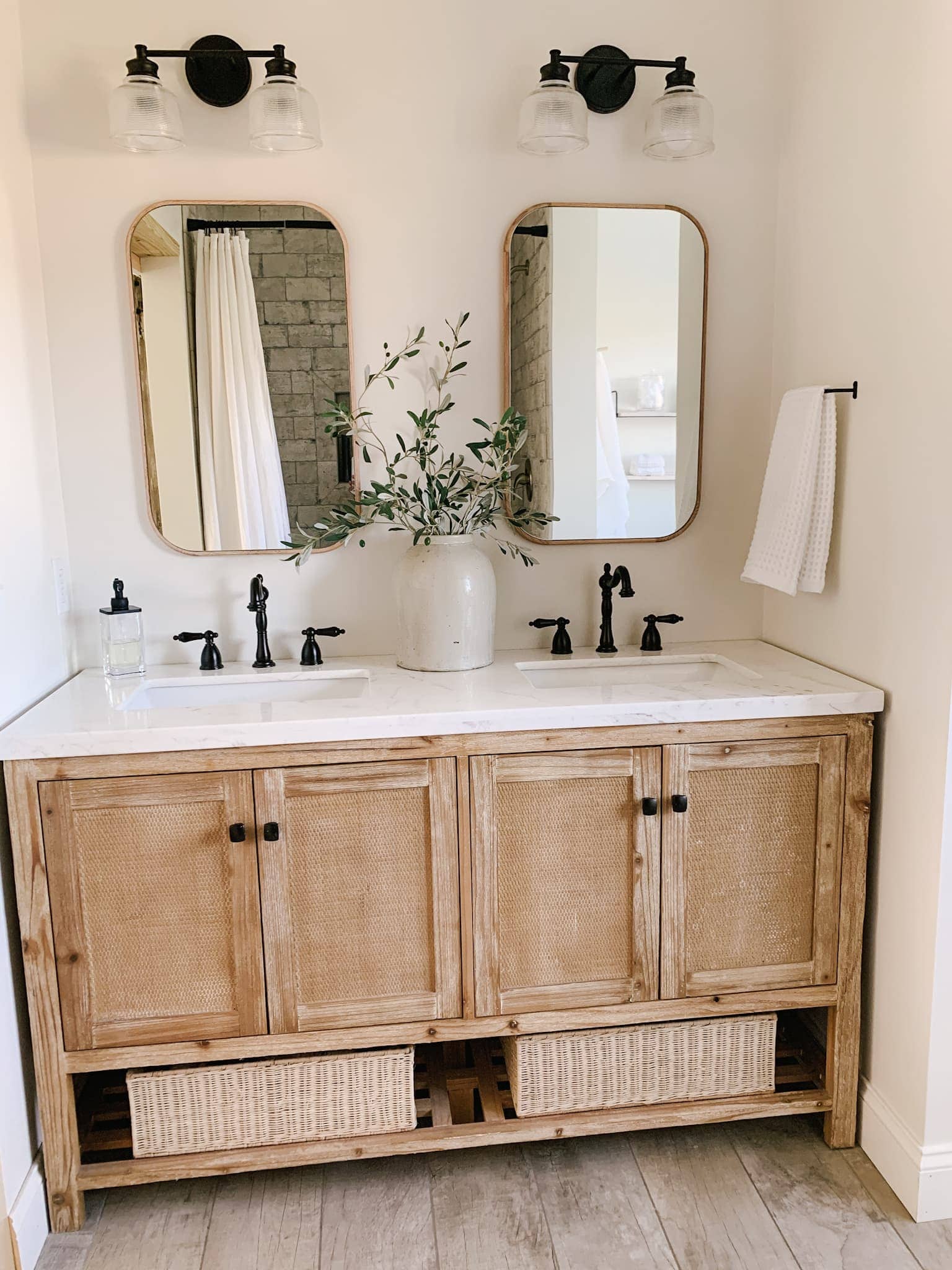 rustic wood cabinet with modern black hardware in this modern farmhouse bathroom